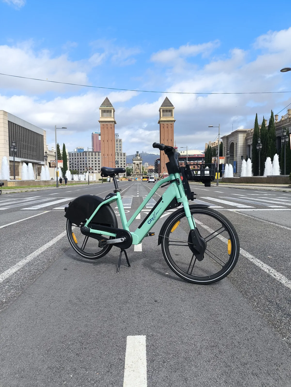 Bici CityFlow en Plaça Espanya, Barcelona — Torres Venecianas al fondo